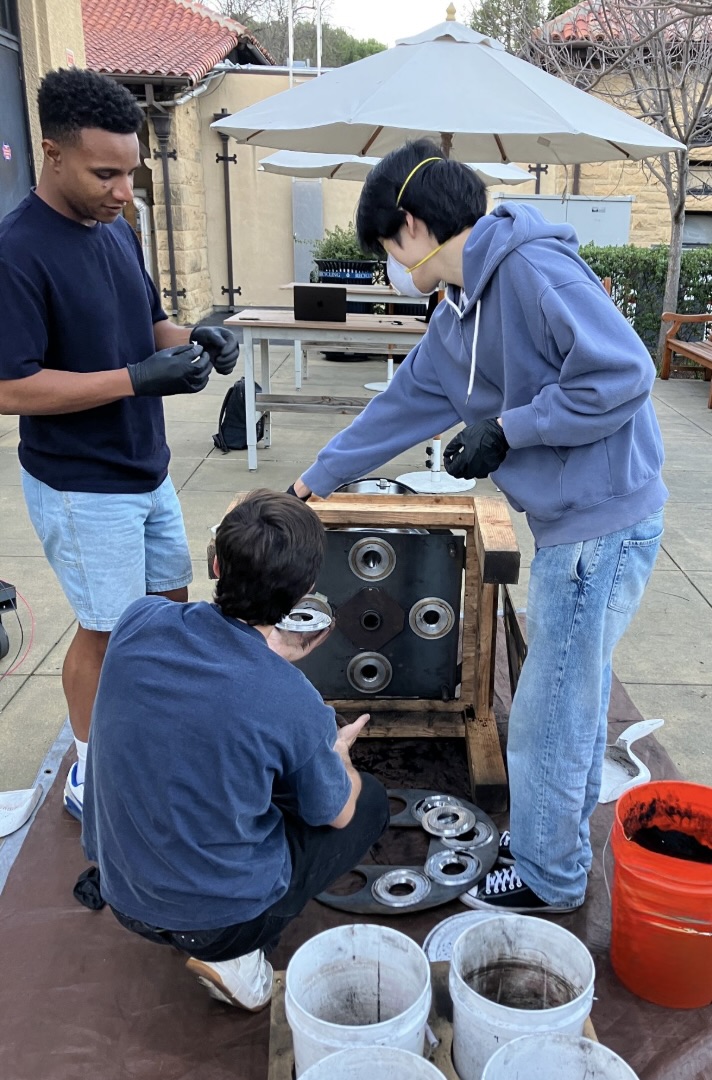 Team tearing down the ACF after testing, coal-covered plates and buckets visible